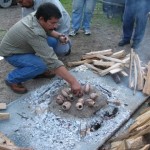 Placing the pots on the wire screen on a bed of coals